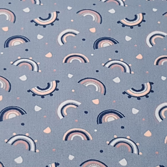 Cotton Dusty Blue Rainbow fabric - Cotton fabric with drawings of rainbow-like arcs of strokes on a powder blue background with shapes in shades of pink. The fabric is 150cm wide and its composition is 100% cotton.