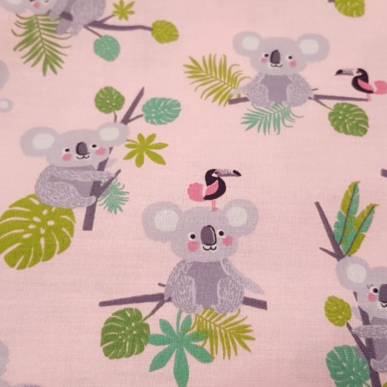 Tela Algodón Koalas y Tucanes - Tela de algodón infantil con dibujos de koalas sobre ramas de árbol y tucanes, sobre un fondo rosa suave. Una preciosidad de tela! La tela mide 140cm de ancho y su composición 100% algodón.