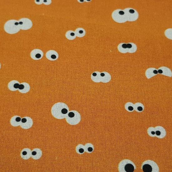 Tela Algodón Ojitos Mirones Naranja - Tela de algodón con dibujos de ojos mirones sobre un fondo de color naranja. La tela mide 150cm de ancho y su composición 100% algodón.