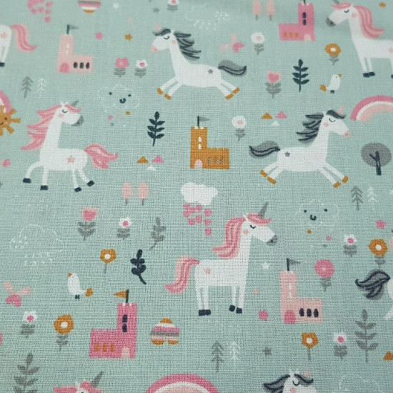 Cotton Unicorns Castles Green fabric - Children's cotton fabric with drawings of unicorns on a green background with castles, plants, rainbows... The fabric is 150cm wide and its composition is 100% cotton.