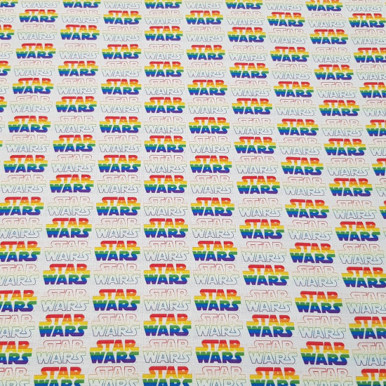 Tela Algodón Star Wars Logos Arcoiris - Tela de algodón licencia con dibujos de logotipos de Star Wars en arcoiris. La tela mide entre 140-150cm de ancho y su composición 100% algodón.