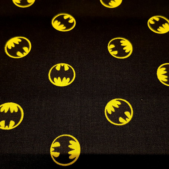 Tela Algodón Batman Logo Circular Negro - Tela de algodón licencia ancho americano con dibujos del logotipo de Batman en círculos sobre un fondo negro. La tela mide 110cm de ancho y su composición 100% algodón.