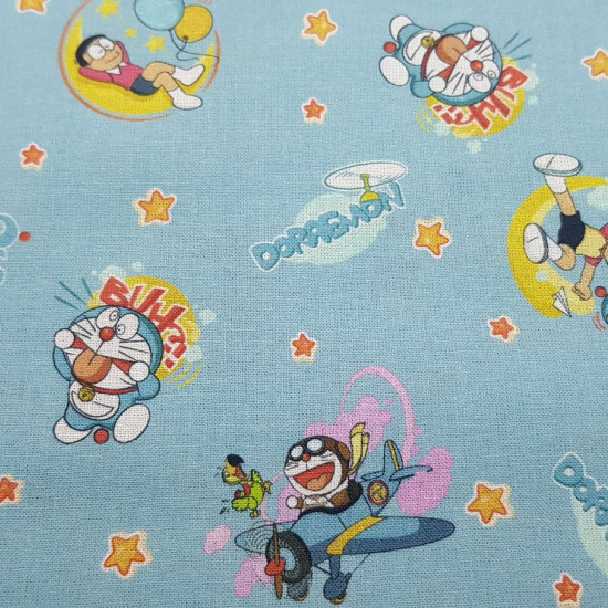 Cotton Doraemon Nobita fabric - Licensed cotton fabric with drawings of the characters Doraemon and Nobita on a background with stars. The fabric measures between 140-150cm wide and its composition is 100% cotton.