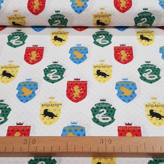 Cotton Harry Potter Shields Schools Polka Dots fabric - Harry Potter licensed cotton poplin fabric with drawings of the shields of the different Hogwarts schools on a white background with polka dots. The fabric measures 110cm wide and its composition is 