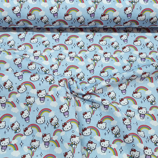 Tela Algodón Hello Kitty Nubes Azul - Tela de algodón licencia con dibujos del personaje Hello Kitty sobre un fondo en tono azul con arcoiris y nubes. La tela mide entre 140-150cm de ancho y su composición 100% algodón.