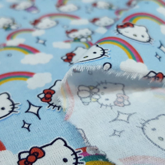 Tela Algodón Hello Kitty Nubes Azul - Tela de algodón licencia con dibujos del personaje Hello Kitty sobre un fondo en tono azul con arcoiris y nubes. La tela mide entre 140-150cm de ancho y su composición 100% algodón.