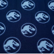 Tela Algodón Jurassic Logos Azul - Tela de algodón con dibujos de logos de Jurassic Park de color azul claro sobre un fondo de color azul oscuro. La tela mide 150cm de ancho y su composición 100% algodón.