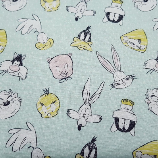 Tela Algodón Looney Tunes - Tela de algodón ancho americano licencia con dibujos de los personajes de la Warner Looney Tunes, donde aparece el conejo Bugs Bunny, el Pato Lucas, Taz, el gato Silvestre, Porky... sobre un fondo de color verde claro.