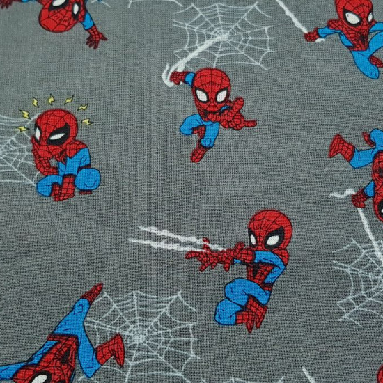 Tela Algodón Marvel Spiderman Mini - Tela de algodón ancho americano licencia con dibujos de Spiderman colgado de telarañas y un tanto cómico, sobre un fondo de color gris.  La tela mide 110cm de ancho y su composición 1