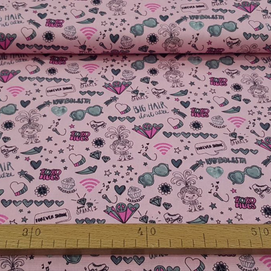 Cotton Trolls Peace Love Pink fabric - Dreamworks licensed children's cotton fabric with drawings of Trolls, with many objects, symbols, phrases... on a pink background. The fabric is 150cm wide and its composition is 100% cotton.