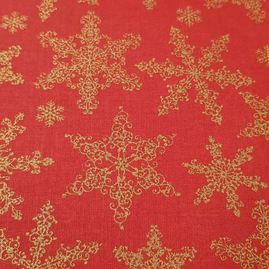 Tela Algodón Navidad Estrellas Doradas Rojo - Tela de algodón con dibujos de estrellas o copos dorados sobre fondo rojo. La tela mide 150cm de ancho y su composición 100% algodón.