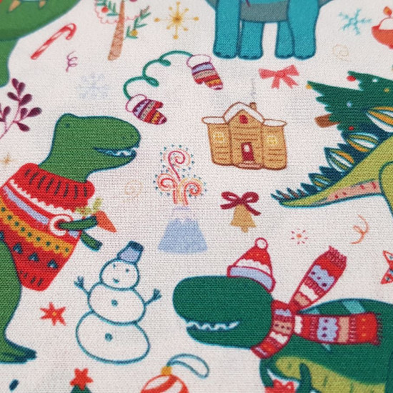 Tela Algodón Navidad Dinosaurios - Tela de algodón popelín muy graciosa con dibujos de dinosaurios en navidad. Aparecen tiranosaurios con jerseys navideños, diplodocus con luces por el cuello, volcanes, muñecos de nieve... Esta tela la podemos encontrar e
