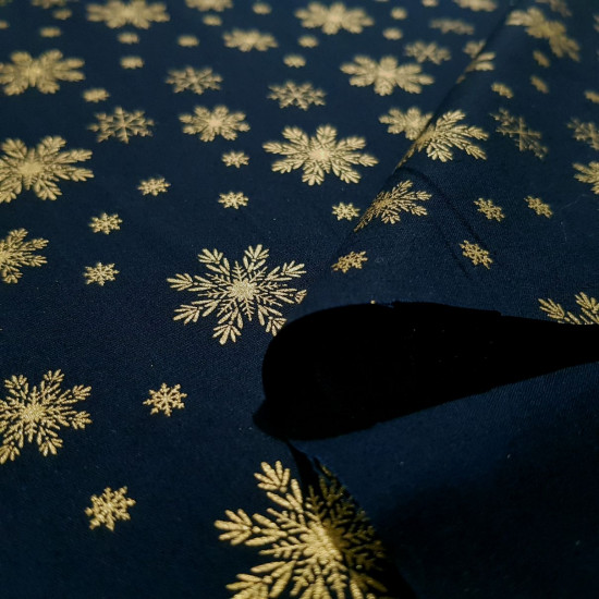 Algodón Navidad Copos Nieve Fondo Azul - Tela de popelín algodón ideal para patchwork de temática navideña, con dibujos de copos de nieve dorados en varios tamaños sobre un fondo de color azul oscuro. La tel
