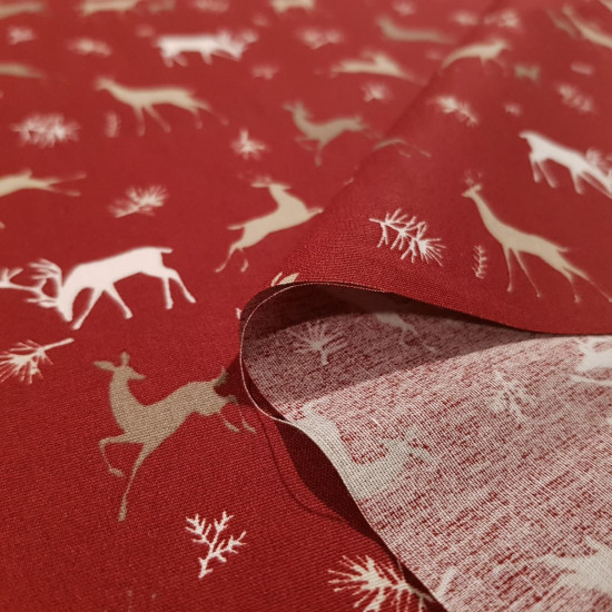 Cotton Christmas Reindeer Red fabric - Christmas cotton poplin fabric with reindeer drawings in various sizes on a red background. The fabric measures 150cm wide and its composition is 100% cotton.