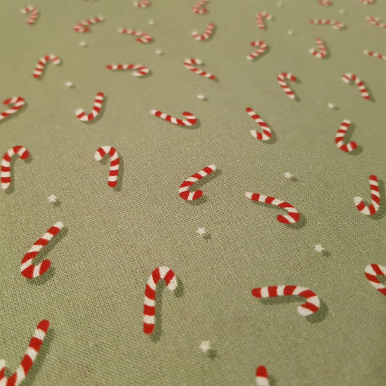 Algodón Navidad Bastones Caramelo - Tela de popelín algodón orgánico con dibujos de bastones de caramelo típicos de navidad, sobre un fondo de color verde. La tela mide 145cm de ancho y su composición 100% algod&oacut