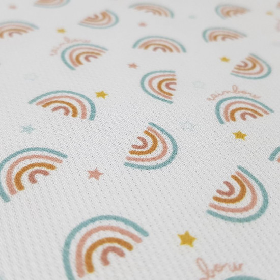 Cotton Pique Rainbow fabric - Cotton pique fabric with rainbow drawings and 'rainbow' letters on a white background, ideal for children's clothing. The fabric is 160cm wide and its composition is 100% cotton.