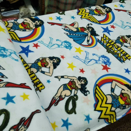 Poly Fleece Wonder Woman fabric - DC Comics licensed poly fleece fabric with Wonder Woman drawings on a white background with colored stars. This fabric is ideal for making blankets and large projects. The fabric measures 145cm wide and its 100% poly