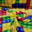 Coral Fleece Building Blocks Colors fabric - Coral fleece fabric with pictures of colored building blocks, similar of Lego blocks and others. The fabric is 150cm wide and its composition is 100% polyester.