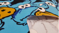 Tela Punto Algodón Monstruo Galletas Triki - Tela de punto algodón con dibujos divertidos del personaje Triki (El monstruo de las galletas) de la famosa serie El Barrio Sésamo. La tela mide 155cm y su composición 92% algodón – 8% elastano