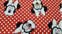 Tela Punto Algodón Minnie Gafas - Tela de punto algodón tipo camiseta licencia Disney con dibujos de Minnie con gafas de varios colores sobre un fondo rojo con lunares blancos. La tela mide 150cm de ancho y su composición 95% algod&oacu