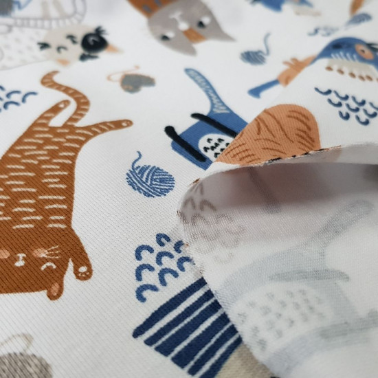 Tela Punto Camiseta Gatitos Ovillos - Tela de punto algodón orgánico tipo camiseta con dibujos de muchos gatitos y ovillos de lana sobre un fondo blanco. La tela mide 150cm de ancho y su composición 95% algodón - 5% elast