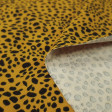 Cotton Jersey Panther Ocher fabric - Cotton jersey fabric with panther-style animal print patterns on an ocher background. The fabric is 150cm wide and its composition is 95% cotton - 5% elastane.