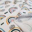 Punto Camiseta Arcoíris Nubes - Tela de punto algodón camiseta con dibujos de arcoíris de colores y nubes sobre un fondo blanco. La tela mide 140cm de ancho y su composición 94% algodón - 6% elastano.
