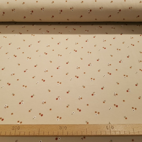 Cotton Jersey Little Flowers Beige Background fabric - Cotton jersey fabric with floral drawings of small scattered flowers in rust, orange and white tones on a beige/sand background. The fabric is 145cm wide and its composition is 95% cotton - 5% elastan