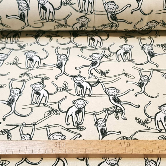 Sweatshirt Alpenfleece Monkeys fabric - Sweatshirt fabric with fur on one side and drawings of monkeys hanging from tree branches on a cream-colored background on the other. The fabric is 150cm wide and its composition is 56% polyester - 40% cotton - 4% e