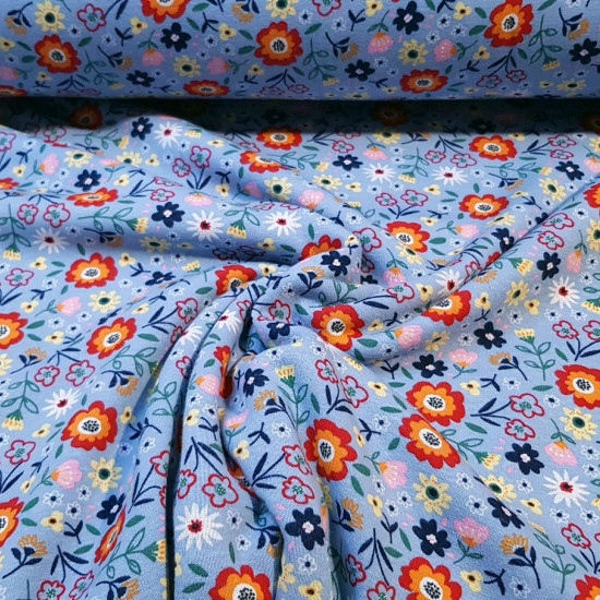 Sweatshirt Alpenfleece Flowers fabric - Winter sweatshirt fabric with fur on one side and drawings of colored flowers on a blue background on the other. The fabric is 150cm wide and its composition is 56% polyester - 40% cotton - 4% elastane.