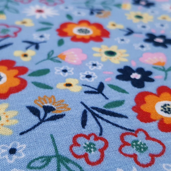 Sweatshirt Alpenfleece Flowers fabric - Winter sweatshirt fabric with fur on one side and drawings of colored flowers on a blue background on the other. The fabric is 150cm wide and its composition is 56% polyester - 40% cotton - 4% elastane.