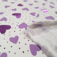 Punto Camiseta Corazones Foil - Tela de punto algodón tipo camiseta con dibujos de corazones de color lila y algunos de ellos efecto brillante (foil) y topitos negros diminutos sobre un fondo blanco. La tela mide 150cm de ancho y su composic