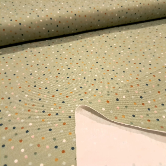Cotton Jersey Colorful Dots fabric - Cotton jersey fabric with drawings of colored dots on a greenish background. The fabric is 150cm wide and its composition is 95% cotton - 5% elastane.
