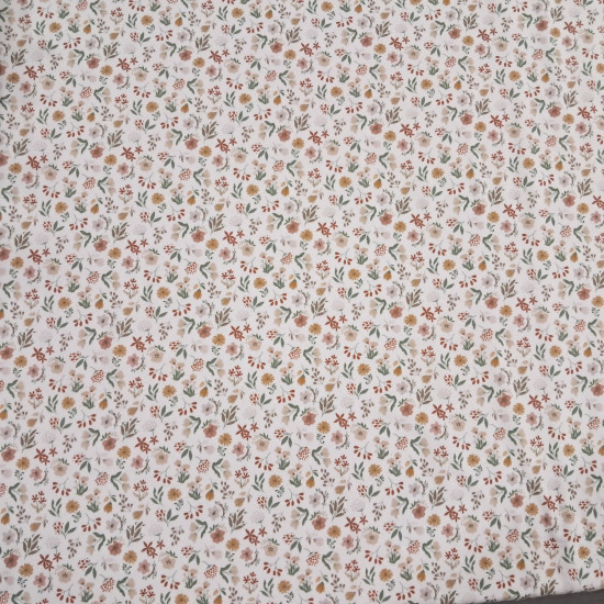 Cotton Jersey Little Spring Flowers fabric Detail of white cotton knit fabric with a small floral print in mustard, pink and green tones