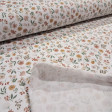 Cotton Jersey Little Spring Flowers fabric Detail of white cotton knit fabric with a small floral print in mustard, pink and green tones