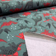 Cotton jersey fabric with red dinosaur print on moss green background