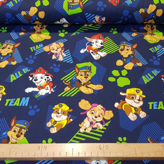 Cotton Jersey Paw Patrol Navy blue fabric - Cotton jersey fabric with drawings of the Paw Patrol characters on a navy blue background with colored footprints. The fabric is 155cm wide and its composition 95% cotton - 5% elastane