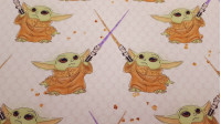 Tela Punto Camiseta Mandalorian Baby Yoda Sable Luz Claro - Tela de punto camiseta algodón con dibujos del personaje Baby Yoda de la serie de Star Wars The Mandalorian, con sables de luz sobre un fondo claro. La tela mide 155cm de ancho y su composición 9