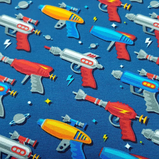 Cotton Jersey Space Toy Guns fabric - Very funny digital print cotton jersey fabric with drawings of space toy guns on a blue background. The fabric is 150cm wide and its composition is 94% cotton - 6% elastane.
