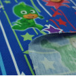 Tela Punto Camiseta PJ Masks Rayas Estrellas - Tela de punto algodón licencia tipo camiseta con dibujos de los personajes PJ Masks sobre un fondo con rayas y estrellas en varios colores sobre un fondo de color azul. La tela mide 160cm de ancho y su compos