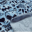 Cotton Jersey GOTS Snoopy Rebel Blue fabric - Organic cotton jersey fabric with drawings of the character Snoopy on a background decorated with blue lines and phrases in black letters, graffiti style where Snoopy and Charlie Brown also appear on a skatebo
