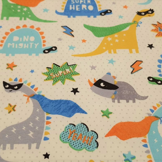 Organic Cotton Jersey Super Dinosaurs fabric - Organic Cotton Jersey Fabric (GOTS) with funny dinosaur drawings with superhero capes, masks and stars, lightning and dots background on off-white background. The fabric is 160cm wide and its composition is 9