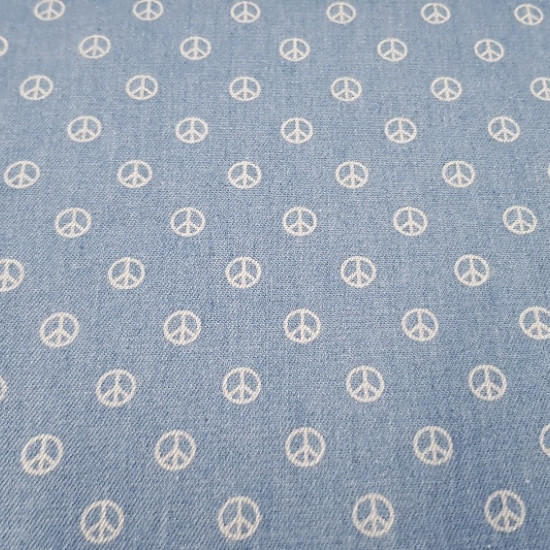 Denim Hippie fabric - Fun fine denim fabric with white hippie peace and love symbols on a light denim background. Very cool accessories can be created with this denim fabric, as well as garments such as skirts, pants and much more. The co