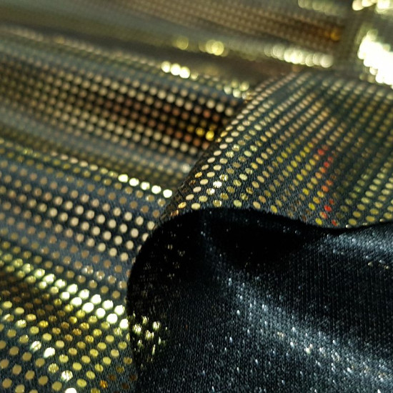 Foil Jersey Gold Circles fabric - Black jersey fabric with tiny foil circles in gold color. Fabric with a lot of shine and fall ideal for bright costumes. The fabric is 150cm wide and its 100% polyester composition.