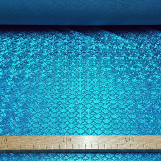 Lycra Mermaid Scales fabric - Fine stretch lycra fabric with drawings of bright mermaid scales, where blue colors predominate. The fabric is 150cm wide and its composition 97% polyester - 3% spandex