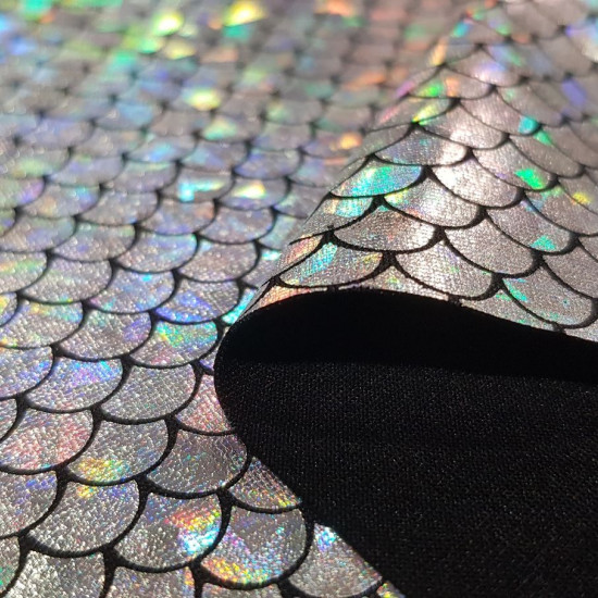 Foil Jersey Mermaid Scales fabric - Black jersey fabric with mermaid scales laminate in some colors with changing effect. It is a fabric that has elasticity and is ideal for costumes, dance clothes … The fabric is 140cm wide and its composition is