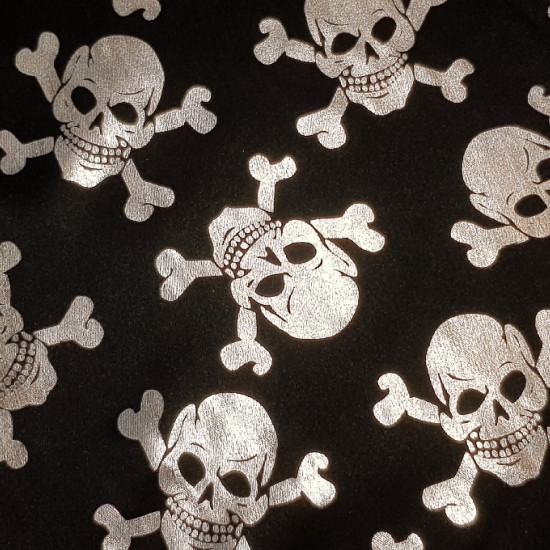 Foil Skulls fabric - Fabric with drawings of shiny silver pirate skulls on a black background. The fabric is a fine lamé/foil fabric, ideal for Halloween costumes and pirate costume accessories. The width of the fabric is 150cm and its c