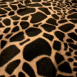 Pelo Mutón Jirafa - Tejido de pelo corto tipo mutón o también llamado velboa, con dibujo estampado característico de jirafa en tonos marrones. La tela mide 150cm de ancho y su composición 100% poliéste