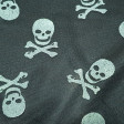 Tulle Skulls fabric - Semi-transparent tulle fabric with drawings of bright pirate skulls on black grid background. A prefect fabric for Halloween and carnival costumes. The fabric measures 150cm and its composition 80% polyester - 20% gl