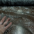Organza Spiderwebs Silver Glitter fabric - Semi-transparent organza/chiffon fabric in black with spider web designs made with silver glitter. In them you can also see the spiders hanging from the spiderwebs. The fabric measures 145cm wide and its 100% pol